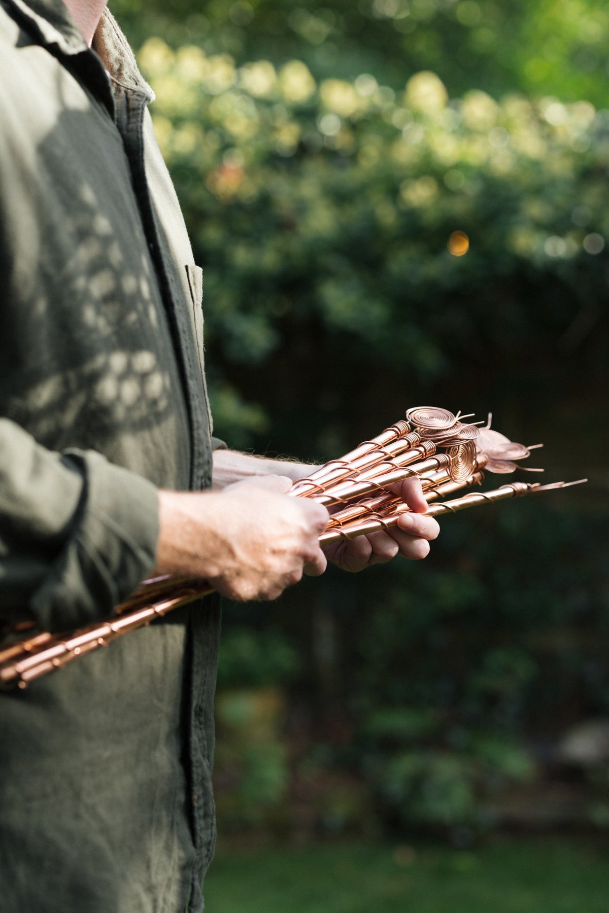 Kopero Électroculture, un bouquet d'antennes en cuivre dans deux mains dans le jardin