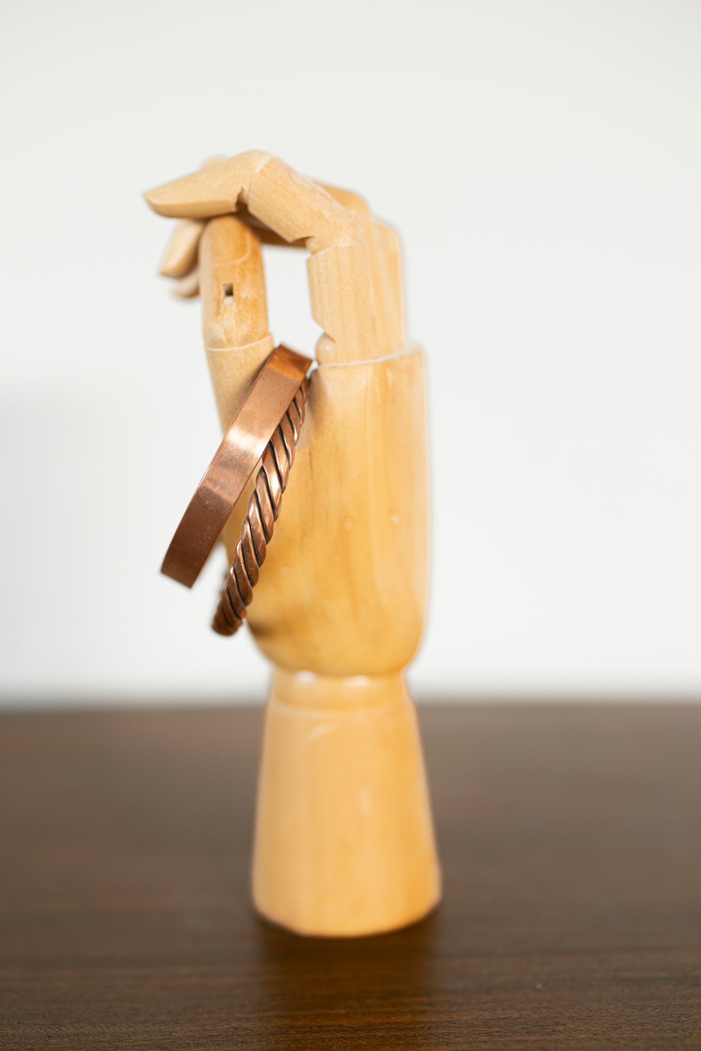 Kopero Premium Bracelets en Cuivre Torsadé et Lisse, vue de côté sur main à bijoux en bois