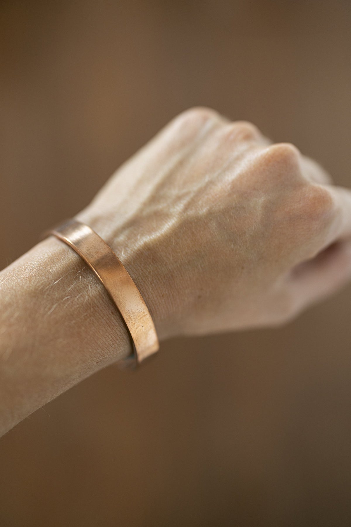 Bracelet en cuivre Kopero Lisse au poignet, gros plan sur la manchette plate en cuivre