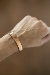 Bracelet en cuivre Kopero Lisse au poignet, gros plan sur la manchette plate en cuivre