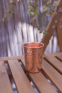 Gobelet en cuivre Kopero Martelé de 300 ml sur un banc de jardin en bois