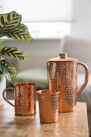 Kopero Mug en cuivre Martelé, à côté d'un gobelet et d'une cruche en même cuivre