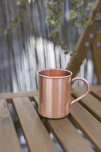 Mug en cuivre Kopero Lisse de 400 ml sur un banc de jardin en bois