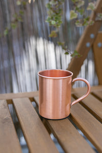 Mug en cuivre Kopero Premium Lisse, 400 ml, 100% cuivre pur, en extérieur sur une table de jardin en bois