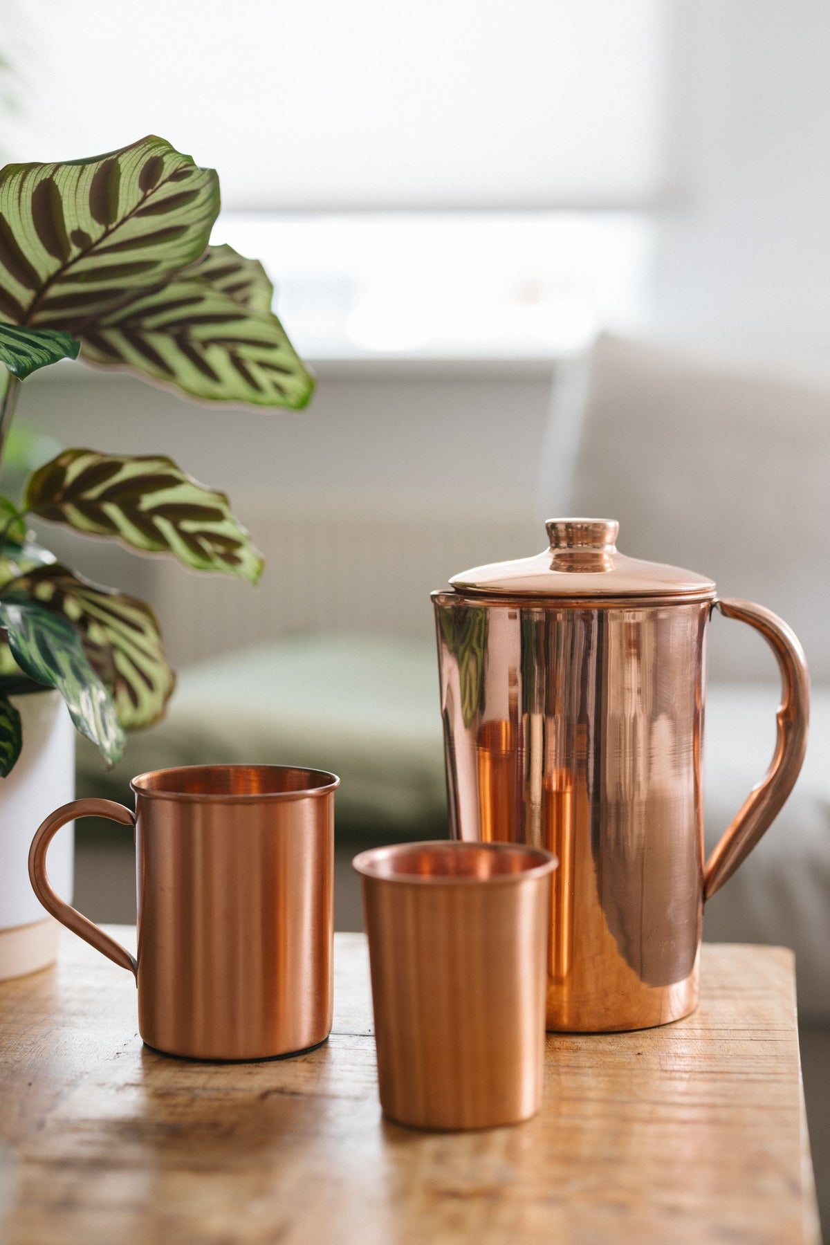 Kopero Mug en cuivre Lisse, à côté d'un gobelet et d'une cruche en même cuivre