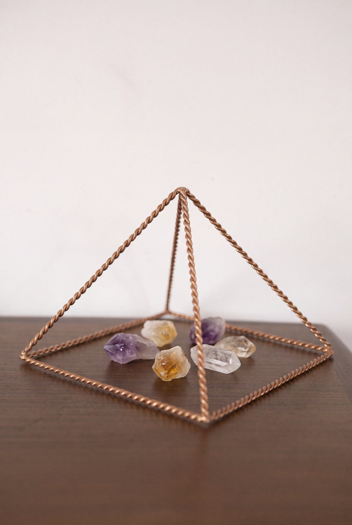 Pyramide énergisante en cuivre torsadé Kopero Petite (14,56 cm) au-dessus d'améthyste et de citrine
