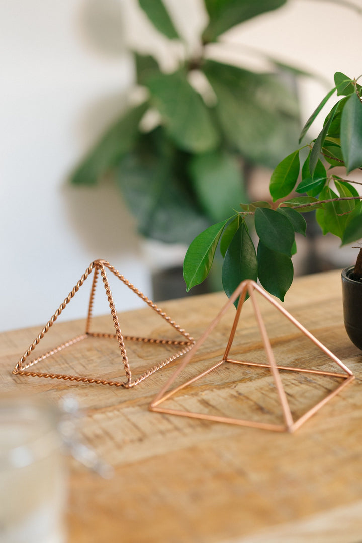 La petite pyramide lisse et la petite pyramide torsadée côte à côte sur une table en bois