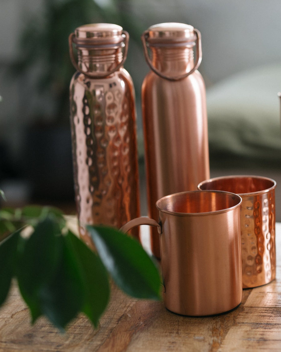 Gourdes en cuivre et mugs sur une table en bois
