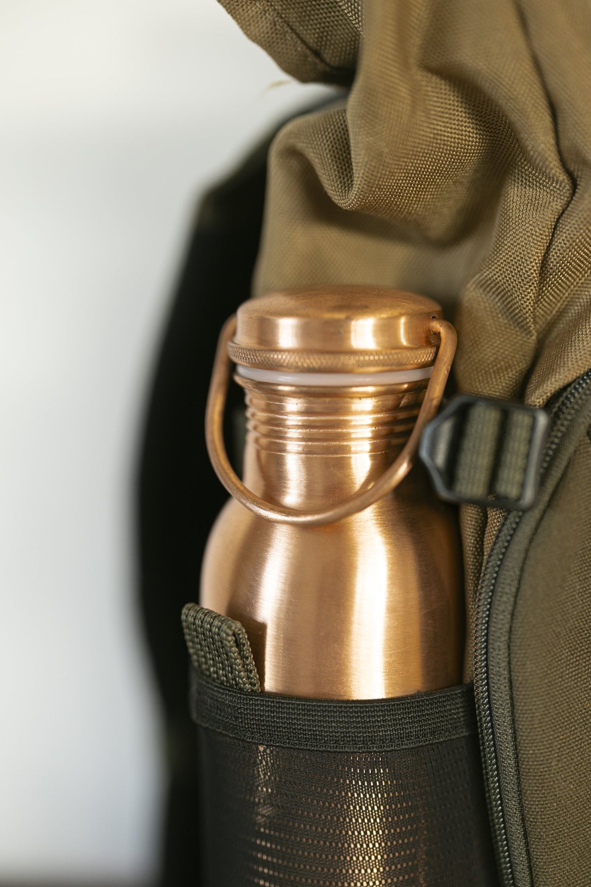 Bouteille d'eau en cuivre Kopero Lisse dans le compartiment à bouteille d'un sac à dos
